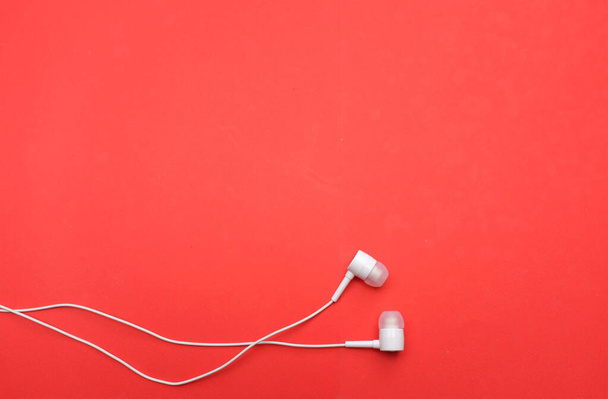 white music headphones ,earphones with headset on isolated bright red background. Music concept. Top view - Valokuva, kuva