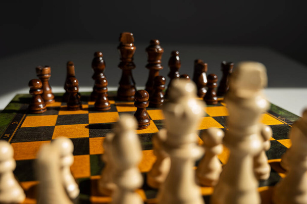 Chessboard with pieces on a white table - 写真・画像