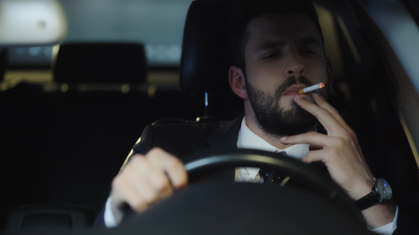 bearded businessman smoking cigarette while driving auto at night - Foto, Bild