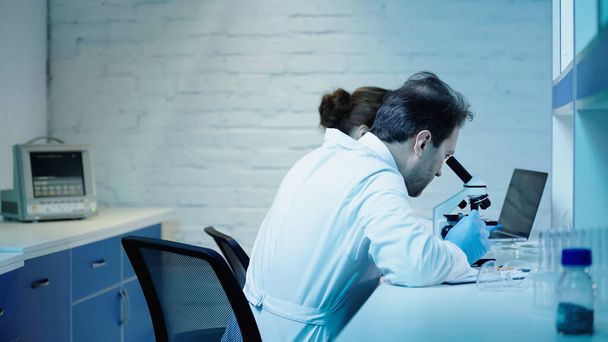 two scientists making research near microscope and laptop in clinical laboratory - Fotoğraf, Görsel