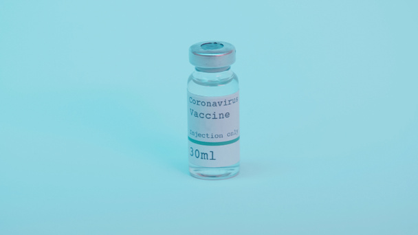 glass bottle with coronavirus vaccine and injection only lettering on blue background  - Foto, afbeelding