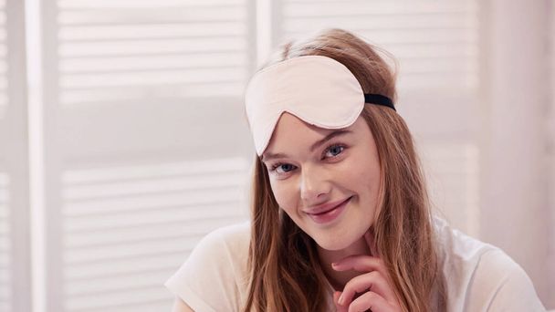 Positive woman in sleep mask looking at camera at home  - Foto, imagen