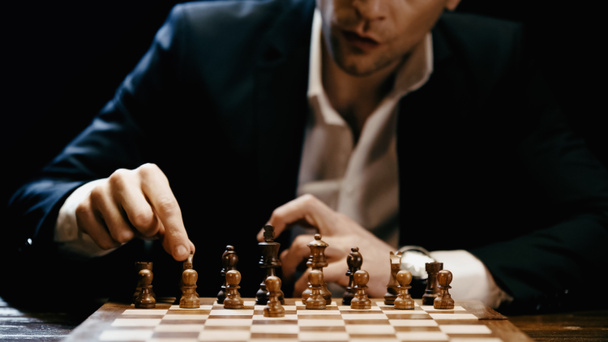 Cropped view of businessman playing chess isolated on black  - Photo, Image