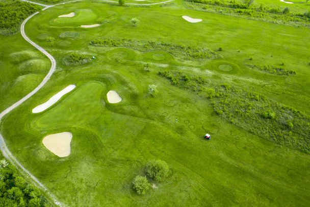 Golf course with sand bunker and green grass, aerial view. - Fotó, kép