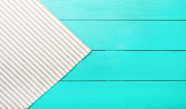 Striped gray and white material on blue wooden background. Top view and copy space. - Photo, Image
