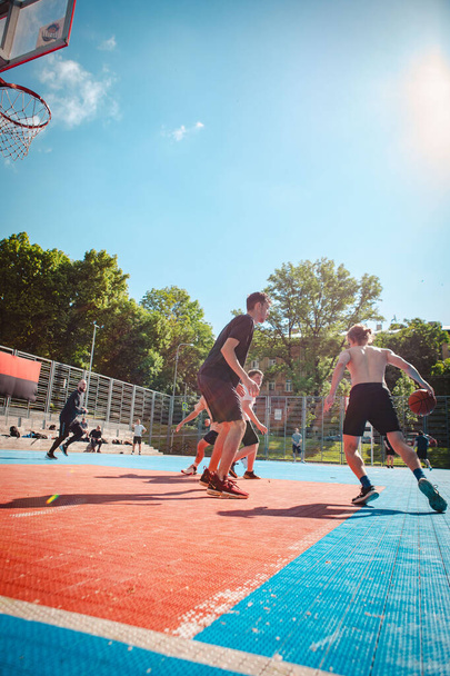 Lwów, Ukraina - 28 maja 2022: mężczyźni grający w koszykówkę na świeżym powietrzu słoneczny letni dzień - Zdjęcie, obraz