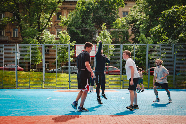 Lviv, Ukraine - 28. Mai 2022: Männer beim Basketballspielen im Freien an sonnigen Sommertagen - Foto, Bild