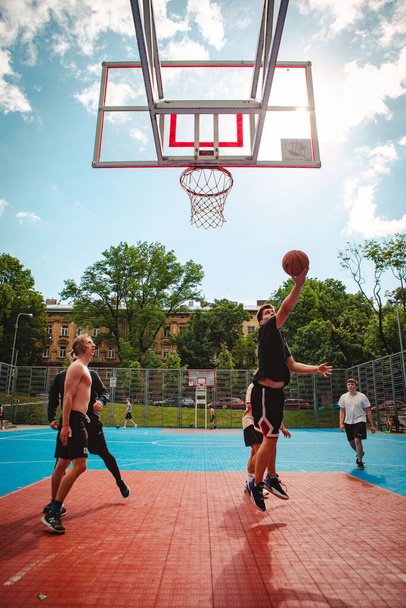 Lvov, Ukrajina - 28. května 2022: muži hrají basketbal venku slunečný letní den - Fotografie, Obrázek