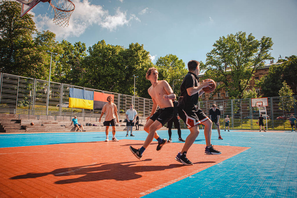 Lviv, Ukraina 28. toukokuuta 2022: miehet pelaavat koripalloa ulkona aurinkoinen kesäpäivä - Valokuva, kuva