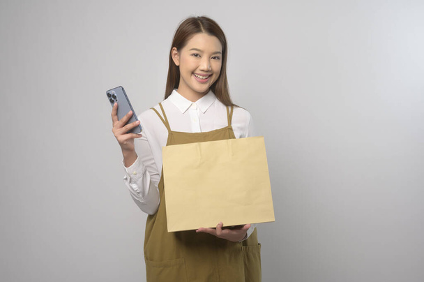 A Portrait of young asian woman wearing apron over white background studio, cooking and entrepreneur concept - Foto, immagini