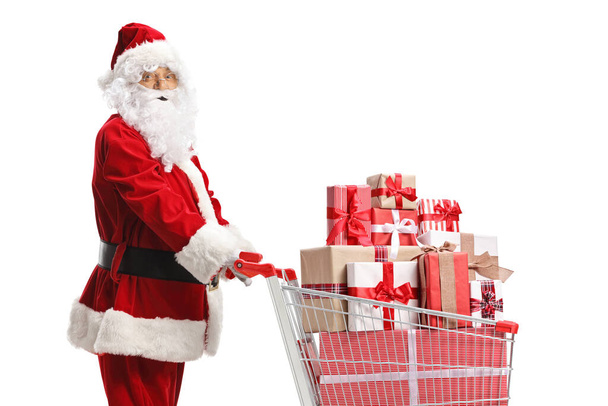 Santa Claus with a shopping cart full of presents isolated on white background - Foto, Imagen