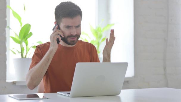 Angry Man Talking on Phone at Work - Valokuva, kuva