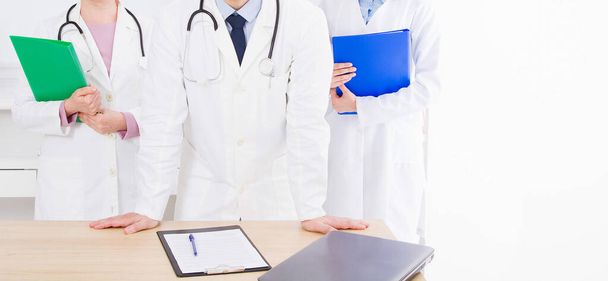 lekarz pozowanie w biurze z personelem medycznym, nosi stetoskop - Zdjęcie, obraz
