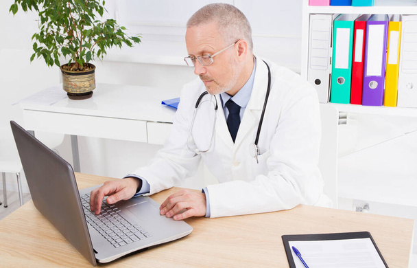 mannelijke arts in de medische dienst werkt op de computer, medische verzekering - Foto, afbeelding