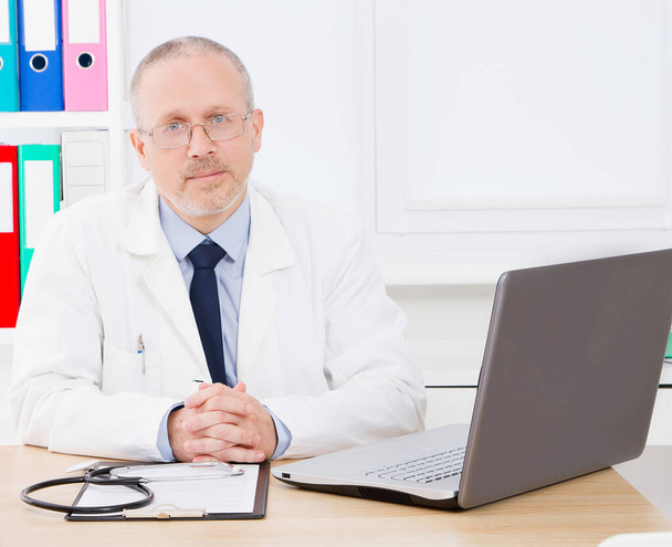 A vezető orvos portréja az orvosi rendelőben. Fehér egyenruhás férfi. Egészségbiztosítás. Másold a helyet. Minőségi orvoslás. Fénymásolási hely - Fotó, kép