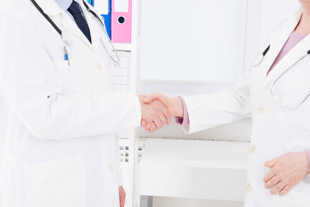 Umowa Koncepcja współpracy w medycynie. Zamknij zdjęcie dwóch lekarzy podających dłoń.Ubezpieczenie medyczne. - Zdjęcie, obraz