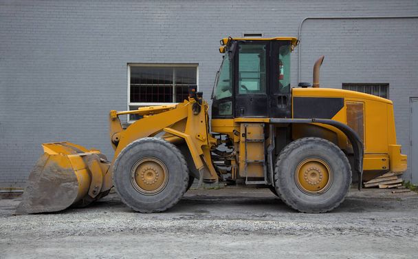 тракторний навантажувач жовтий екскаватор будівельний майданчик важке обладнання гідравлічна лопата
 - Фото, зображення