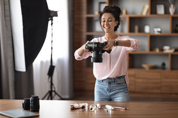 Happy young woman famous beauty blogger taking photos of cosmetics for her blog, using professional camera and other equipment for photoshoot, home interior, copy space. Blogging concept - Φωτογραφία, εικόνα