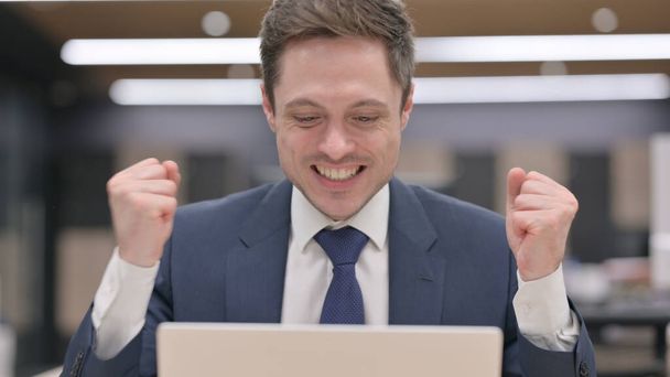 Portrait of Young Businessman Celebrating Success on Laptop - Fotó, kép