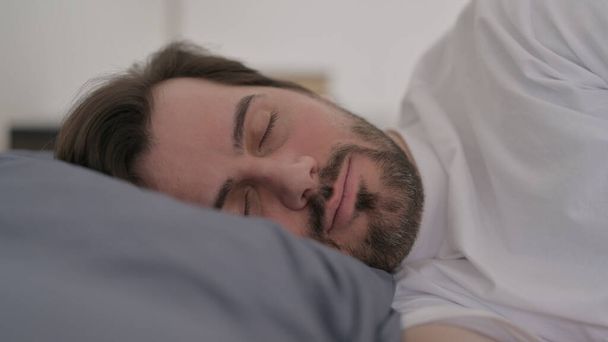 Portrét mladého muže s bradkou, jak klidně spí v posteli - Fotografie, Obrázek