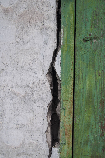 A crack formed between the brick wall of the barn and the fastening of the doors. - Photo, image