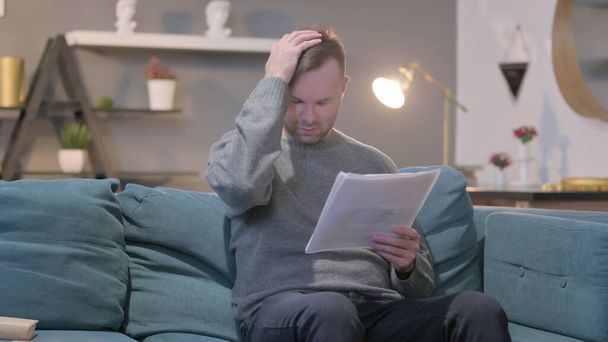 Middle Aged Man Reacting to Loss on Documents, Sofa - Foto, imagen