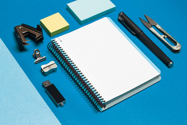 Open graph paper notebook and student utensils on a blue background - Foto, Imagem