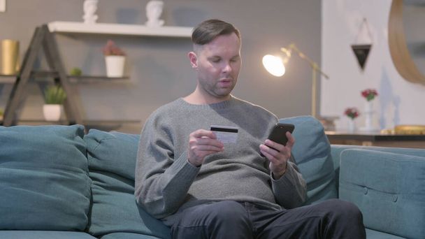 Mann mittleren Alters macht Online-Bezahlung per Smartphone - Foto, Bild