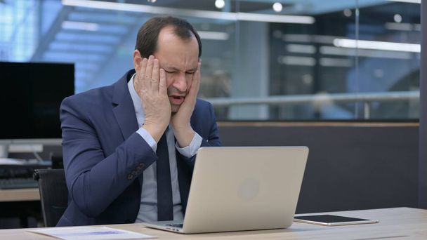 Moyen Age Homme d'affaires réagissant à la perte tout en utilisant un ordinateur portable - Photo, image