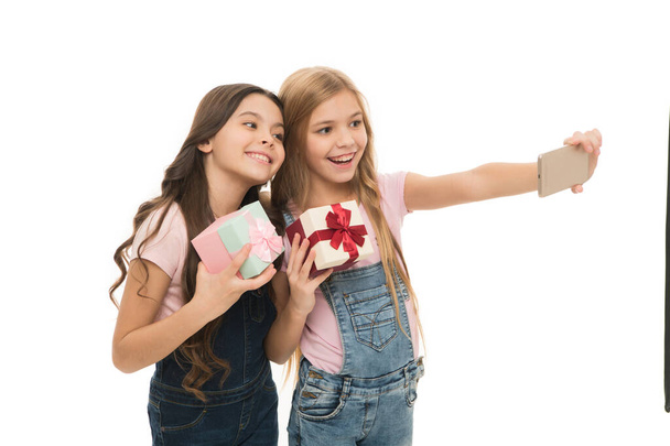 Taking selfie. How make professional unboxing. Girls cute kids shooting unboxing video on smartphone camera. Video call. Vlog online stream and channel. Kid hold gift box. Unboxing birthday gifts. - Foto, Imagem