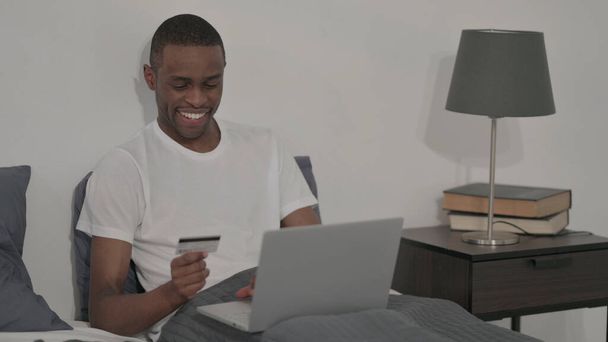 The African Man with Successful Online Payment on Laptop, Sitting in Bed - Zdjęcie, obraz
