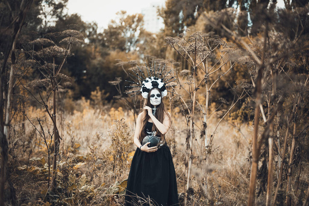 Closeup portrait of Calavera Catrina in black dress. Sugar skull makeup. Dia de los muertos. Day of The Dead. Halloween. - Фото, изображение