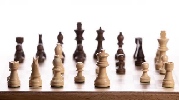 Close up of chess board against white background with the pieces moving in stop motion - Video