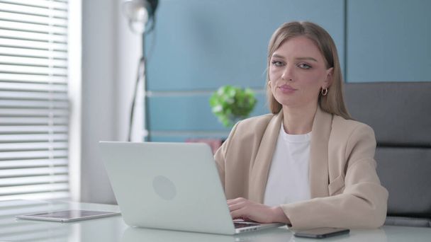Young Businesswoman Shaking Head as No Sign while using Laptop in Office - Foto, Imagen