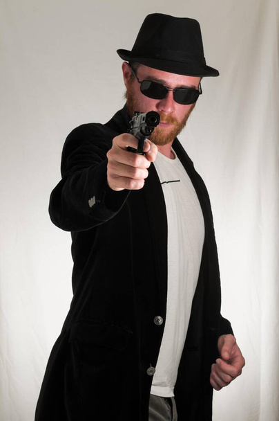 νεαρός άνδρας με όπλο στο στούντιο - Φωτογραφία, εικόνα