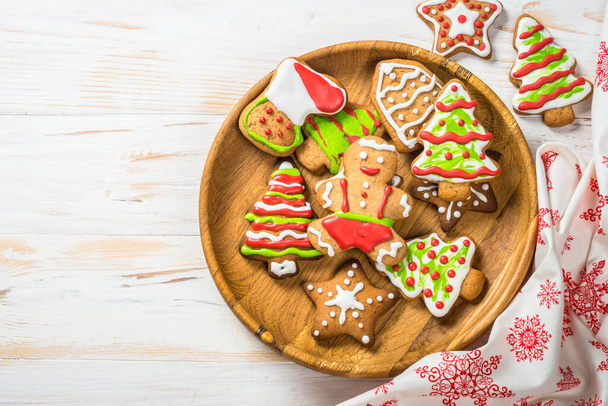 Christmas gingerbread in the plate with spices and decorations on white wooden table. Christmas baking. Top view with copy space. - Photo, Image