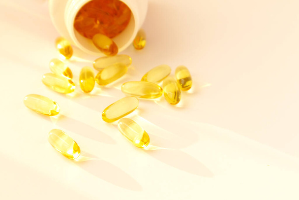 Fish oil pills. Omega 3 gel capsules with bottle on blurred background. - Fotó, kép