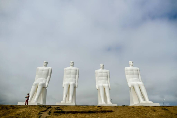 Men at Sea or Man meets the Sea ist ein 9 Meter hohes weißes Denkmal von vier sitzenden Männern, das sich westlich von Esbjerg in der Nähe des Strandes Sadding an der Südwestküste Dänemarks befindet..  - Foto, Bild