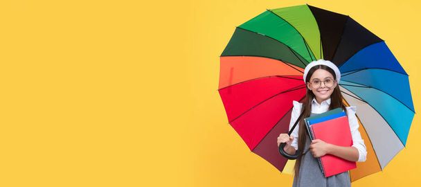 education. teen child under colorful parasol. kid in beret with rainbow umbrella. Child with autumn umbrella, rainy weather, horizontal poster, banner with copy space - Foto, imagen