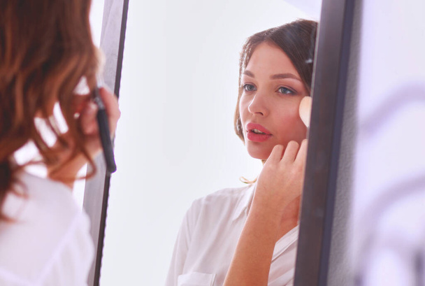 Jeune femme se regardant reflet dans le miroir à la maison. Jeune femme
 - Photo, image