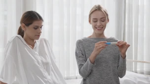 Happiness young caucasian woman taking pregnancy test while excited and satisfied with friends in the bedroom at home, happy mother with smile and expression with love, ovulation and maternity. - Πλάνα, βίντεο