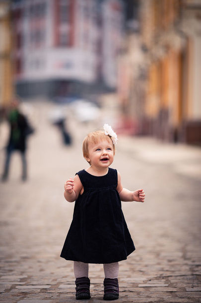 A little baby girl stands on the street - Foto, Imagem