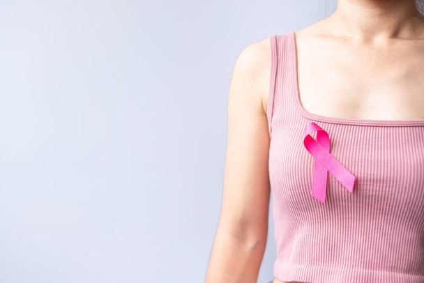 Pink October Breast Cancer Awareness month, woman hand hold pink Ribbon and wear shirt for support people life and illness. National cancer survivors month, Mother and World cancer day concept - Photo, Image