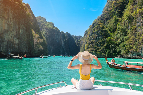 ボート旅行の女性観光客、ピピ島、クラビ、タイのピレラグーンでリラックスした幸せな旅行者。エキゾチックなランドマーク、目的地東南アジア旅行、休暇、休暇のコンセプト - 写真・画像