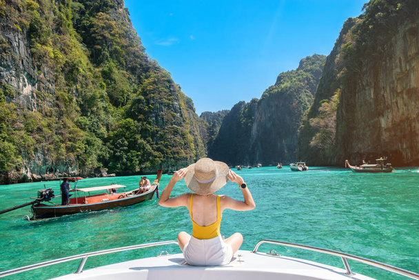 ボート旅行の女性観光客、ピピ島、クラビ、タイのピレラグーンでリラックスした幸せな旅行者。エキゾチックなランドマーク、目的地東南アジア旅行、休暇、休暇のコンセプト - 写真・画像