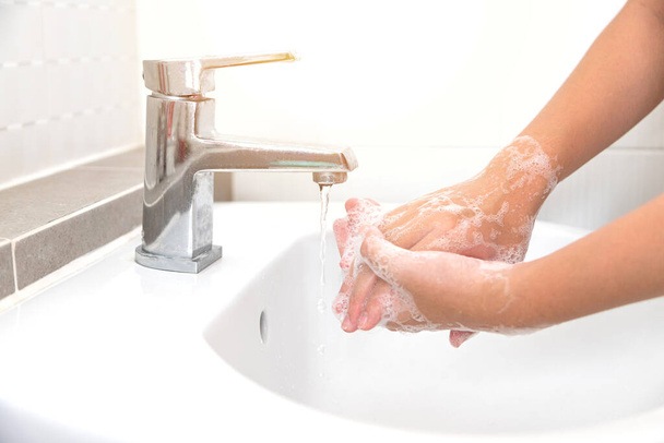 Lavarsi le mani con sapone per la pulizia aiuta a prevenire i germi e Covid-19 - Foto, immagini