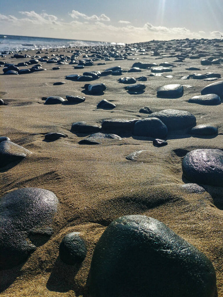 Praia de areia com pedras pretas em Punta de Maspalomas, perto da estância turística de Playa de Ingles, na ilha de Gran Canaria, Espanha - Foto, Imagem