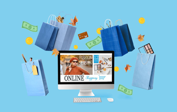 PC monitor, bags, autumn leaves and money on blue background. Online shopping concept - Foto, immagini