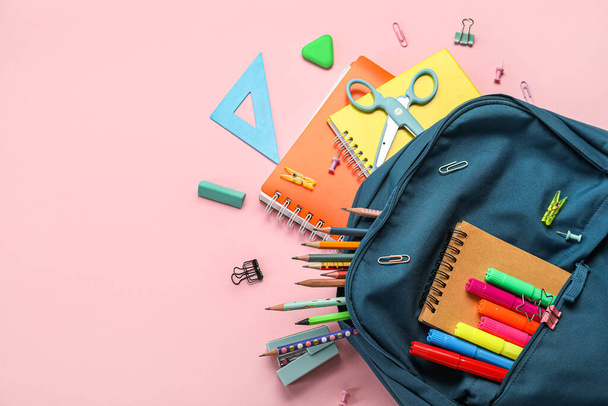 School backpack with stationery supplies on pink background - Foto, afbeelding