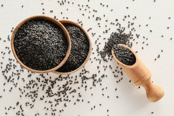 Bowls and scoop with black sesame seeds on light background - Zdjęcie, obraz